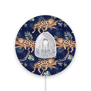 May include: A round, blue mouse mat with a repeating pattern of sleeping leopards on branches. The leopards are brown and black with white spots. The background is a dark blue with white stars.