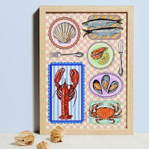May include: A framed print with illustrations of seafood. The artwork includes a red lobster, crab, shrimp, mussels, and fish, along with a scallop shell and cutlery. The background has a pink and white checkered pattern.