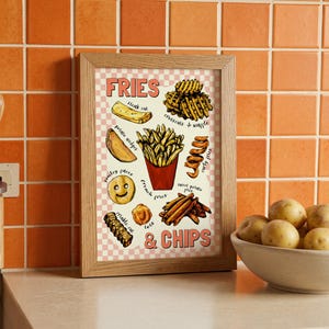 May include: A wooden-framed print displaying illustrations of different types of chips and fries, such as steak cut, waffle, and curly fries. The print has a pink and white checkered background and the words "FRIES & CHIPS". The frame is made of light-colored wood.