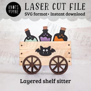 Könnte beinhalten: Ein mehrschichtiges Holzregal mit einem Wagen mit drei Zaubertränken und einer Fledermaus. Die Flaschen sind schwarz mit grüner, lila und orangefarbener Flüssigkeit. Der Wagen hat braune Räder und eine Fledermaus in der Mitte.