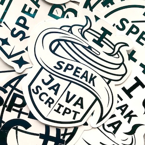 May include: A pile of white stickers with dark teal text and graphics. The stickers feature the words "SPEAK JAVASCRIPT" in a stylized design, along with other related text and symbols. The stickers are scattered across a surface.