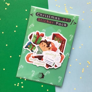 May include: A clear plastic sleeve containing a Christmas API Sticker Pack. The green backing card features white candy cane patterns and the text Christmas API Sticker Pack. Inside are multiple stickers depicting a character with gifts.