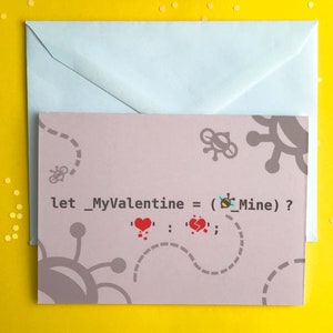 May include: A light pink card with a code-like message that reads "Let_MyValentine = (Bee_Mine) ?" with a bee emoji and two hearts, one whole and one broken. The card has a light blue envelope.