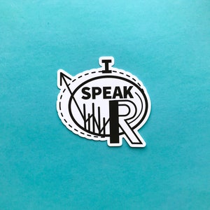 May include: A white sticker with black text and graphics on a teal background. The sticker says "I SPEAK WR" in a stylized font, surrounded by a dotted circle and arrow design.