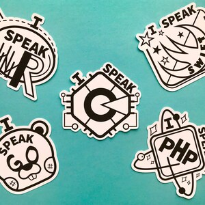 May include: A selection of white stickers with black outlines. Each sticker features the words "I SPEAK" and a programming language or symbol, such as R, C, Swift, PHP, and a bear-like character.