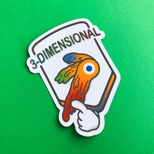 May include: A white sticker with the text "3-DIMENSIONAL" in rainbow colors. The sticker features a cartoon eye with orange, yellow, and blue details, and a white hand pointing at the eye. The sticker is on a green background.