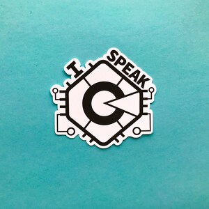 May include: A white sticker featuring a black graphic design and the words "I SPEAK". The design is a stylized circuit board with a central circular element and a pie-shaped wedge. The sticker is on a teal background.