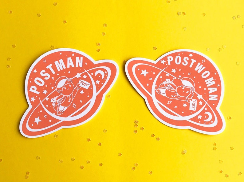 K&ouml;nnte beinhalten: Zwei Aufkleber mit einem roten Planeten-Design. Die Aufkleber zeigen eine Comicfigur, die Post liefert. Ein Aufkleber sagt "POSTMAN" und der andere sagt "POSTWOMAN".