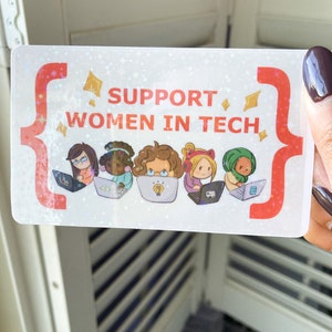 May include: A rectangular sticker with the text "SUPPORT WOMEN IN TECH" in red. The sticker features illustrations of four diverse women working on laptops. The background has a holographic, glittery effect with red and gold accents.