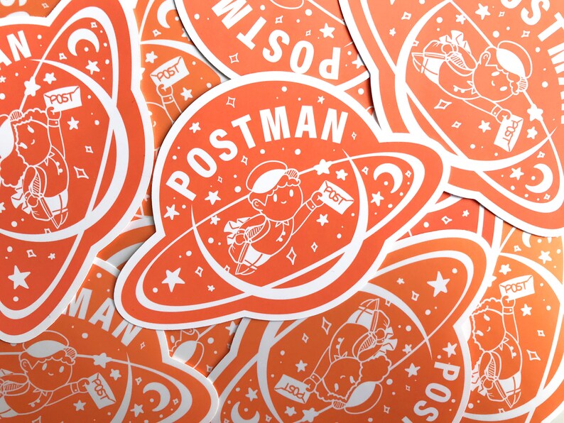 K&ouml;nnte beinhalten: Ein Stapel orangefarbener und wei&szlig;er Aufkleber mit einem Comic-Astronauten, der Post liefert. Die Aufkleber zeigen den Text "POSTMAN" und einen Halbmond.