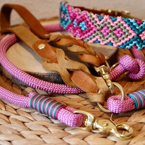 Peut inclure: Trois laisses pour chien en rose, marron et bleu avec des d&eacute;tails tiss&eacute;s color&eacute;s. Les laisses sont en corde et en cuir et ont des fermoirs en m&eacute;tal dor&eacute;.