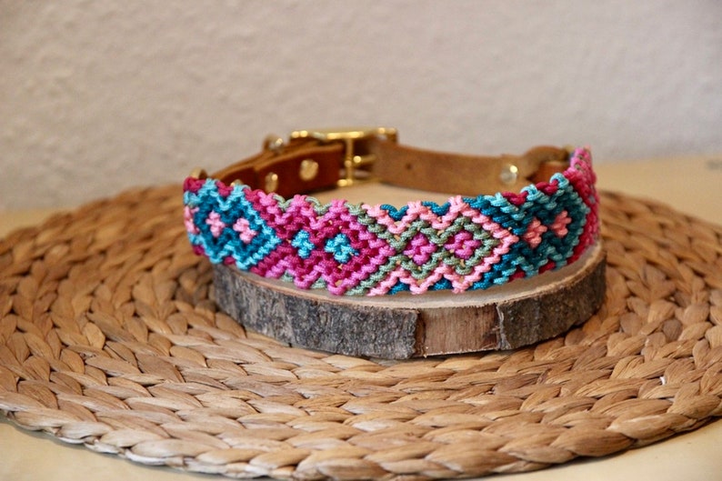 Peut inclure: Un collier pour chien tiss&eacute; color&eacute; avec un motif g&eacute;om&eacute;trique dans des tons de rose, bleu et vert. Le collier est en cuir et poss&egrave;de une boucle en m&eacute;tal dor&eacute;.