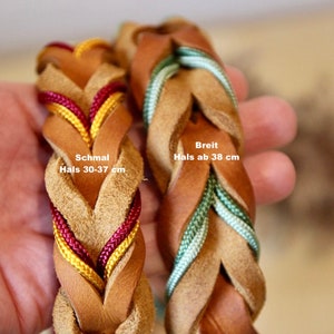 May include: Two braided leather dog collars in brown with different coloured cords. The collar on the left has red and yellow cords and is labelled "Schmal Hals 30-37 cm". The collar on the right has green cords and is labelled "Breit Hals ab 38 cm".