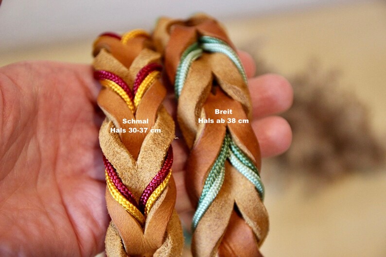 May include: Two braided leather dog collars in brown with different coloured cords. The collar on the left has red and yellow cords and is labelled "Schmal Hals 30-37 cm". The collar on the right has green cords and is labelled "Breit Hals ab 38 cm".