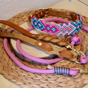 Peut inclure: Un ensemble de trois colliers et laisses pour chien en rose, marron et bleu. Les colliers et les laisses sont faits de diff&eacute;rents mat&eacute;riaux, dont le cuir, la corde et le tissu tiss&eacute;. Les colliers ont des fermoirs en m&eacute;tal dor&eacute;.