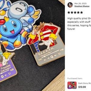 May include: Enamel pins featuring characters from a video game series. The pins include a blue character, a black character, and a character with a diamond. One pin has the text "Fly In The Freedom". Another pin has the text "E.G.G.M.A.N."