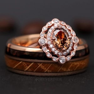 May include: A rose gold wedding band set with a brown oval-shaped gemstone surrounded by a halo of smaller diamonds. The band is made of wood and has a unique wood grain pattern.