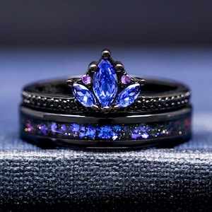 May include: A black wedding band set with a blue and purple gemstone crown design.