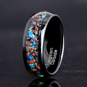 May include: Black tungsten carbide ring with a band of blue, orange, and silver glitter. The ring is engraved with "Tungsten Carbide" on the side. The ring is made by ForeverRings.