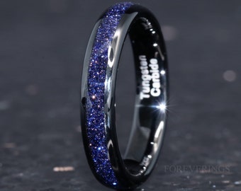 May include: A black tungsten carbide ring with a blue glitter inlay. The ring is inscribed with "Tungsten Carbide".