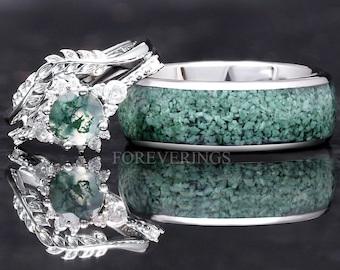 May include: A pair of wedding bands with a green moss agate stone set in a silver band with leaf accents. The other band is silver with a green moss agate inlay.