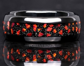 May include: Black tungsten carbide ring with a band of red and orange opal inlay. The ring is polished and has a high shine.
