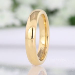 4mm gold tungsten wedding band standing upright, angled to show the polished gold interior