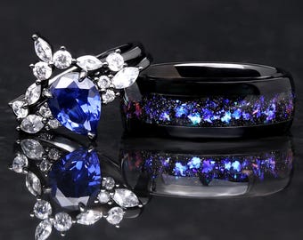 Puede incluir: Un par de anillos de boda. El anillo de la mujer presenta un zafiro azul en forma de pera rodeado de piedras más pequeñas y transparentes. El anillo del hombre es negro con una incrustación de purpurina azul y morada.