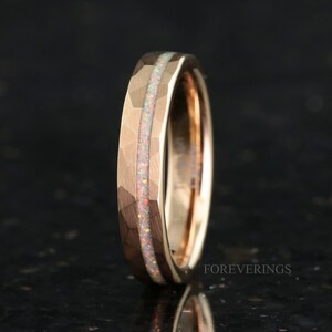 May include: A rose gold tungsten carbide ring with a hammered finish and a thin opal inlay.