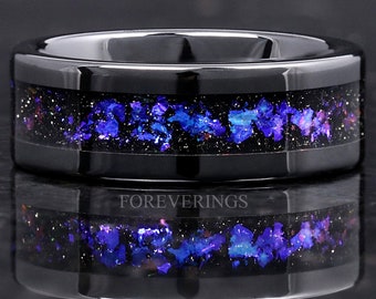 May include: Black tungsten carbide ring featuring a band of blue and purple iridescent glitter embedded in black resin. The ring is engraved with the text "FOREVERINGS".
