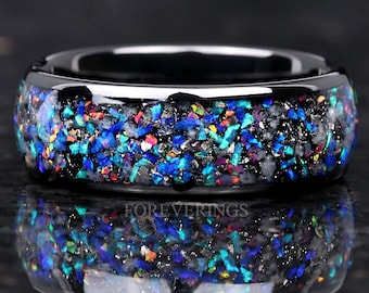 May include: Black ring with a band of iridescent blue, green, and red glitter embedded in clear resin.