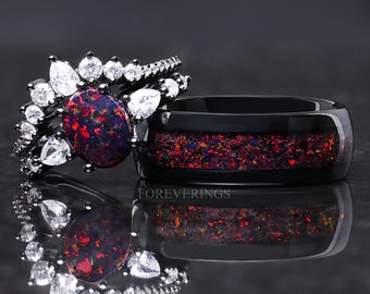 Könnte beinhalten: Ein schwarzer Ring mit einem großen, ovalen, rot-blauen Opal-Edelstein, der von kleineren, klaren Edelsteinen umgeben ist. Die Band ist schwarz und hat eine dünne Linie aus rot-blauem Opal.