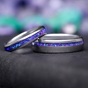 May include: Two silver wedding bands with a thin purple and blue glitter inlay.