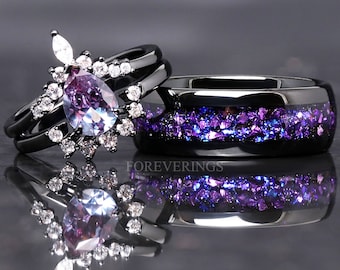 Puede incluir: Una banda de boda negra con purpurina morada incrustada en la banda y un anillo de compromiso negro con una piedra preciosa morada en forma de pera rodeada de piedras preciosas transparentes más pequeñas.