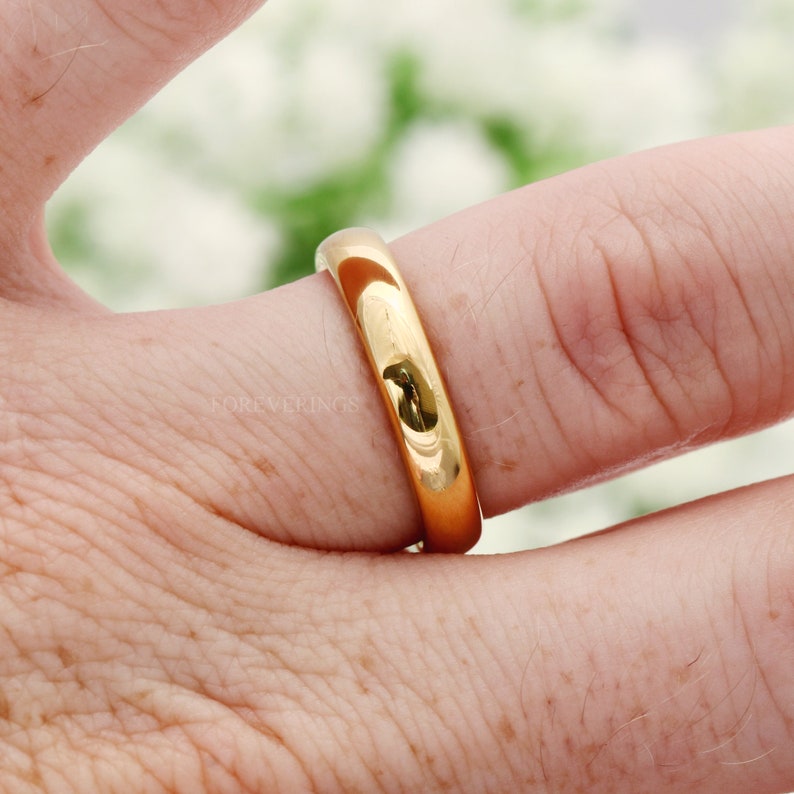 4mm gold tungsten band worn on a finger, close-up of the polished dome