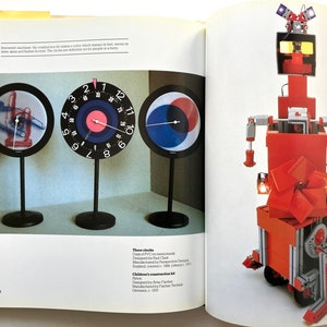May include: Three clocks with different designs, including a clock with a hand pointing to the time, a clock with a target design, and a clock with a circle design. A red and white robot toy with a spinning fan and wheels.