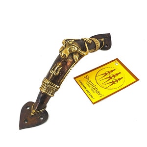 Puede incluir: Un tirador de puerta de bronce con un diseño decorativo de cabeza de toro y detalles intrincados. El tirador tiene una base en forma de corazón y una etiqueta con el texto "Shambhavi Creations Handmade with Love!"