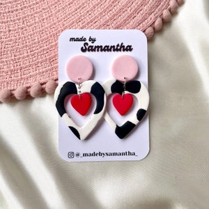 Cut out heart shaped polymer clay cow print earrings with pink and red details and charm Pink
