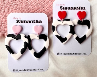 Boucles d&#39;oreilles en forme de coeur en pâte polymère avec imprimé vache et détails roses et rouges