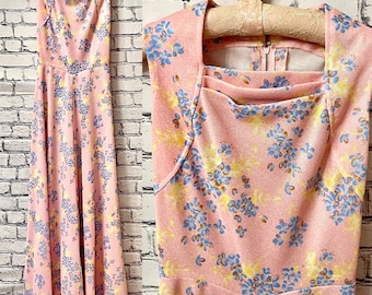 May include: A pink sleeveless maxi dress with a floral print featuring blue and yellow flowers. The dress has a square neckline and a back zipper closure.