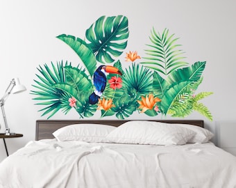 May include: A white bed with a headboard featuring a tropical wall decal. The decal features a toucan bird with a blue and orange body, green leaves, and orange flowers.