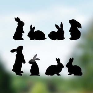 May include: Silhouettes of eight black rabbits in various poses, including standing, sitting, and hopping. The rabbits are all facing forward and are set against a blurred background of blue and green.