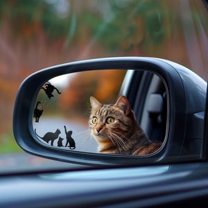 Könnte beinhalten: Eine braune getigerte Katze schaut aus dem Rückspiegel eines Autos. Der Spiegel hat mehrere schwarze Katzensilhouetten darauf.