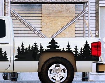 Puede incluir: Una camioneta blanca con una silueta negra de un bosque en el lateral de la caja de la camioneta. La camioneta está estacionada en una calle frente a un edificio en construcción.