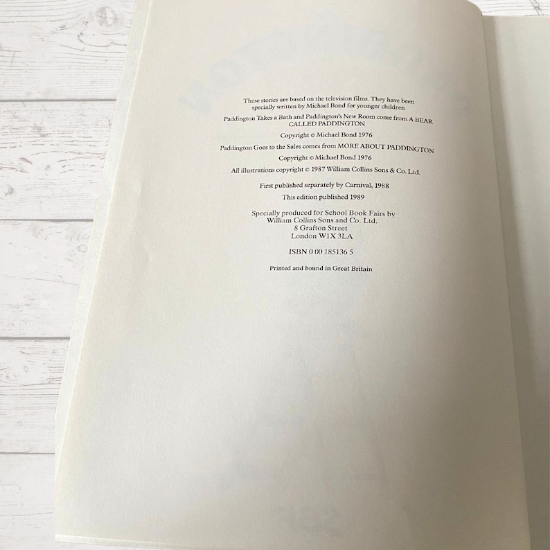 Pode incluir: Uma capa de livro com o t&iacute;tulo "Paddington Takes a Bath and Paddington's New Room" de Michael Bond. O livro faz parte de uma s&eacute;rie chamada "A Bear Called Paddington". As informa&ccedil;&otilde;es de direitos autorais s&atilde;o listadas como 1976 e 1987. O livro foi publicado pela Carnival em 1988 e 1989.