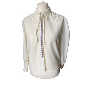 Vintage embroidered blouse with peter pan collar, tie neck and long deep cuffed sleeves and pink and blue flowers.Approx U.K. size 12-14