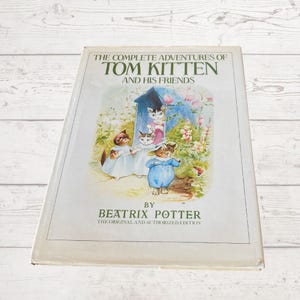 May include: A vintage hardcover book titled "The Complete Adventures of Tom Kitten and His Friends" by Beatrix Potter. The book cover features an illustration of four kittens in a garden setting.