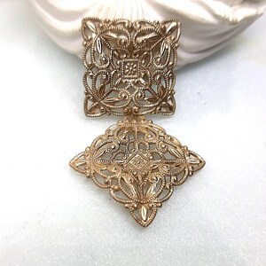 Könnte beinhalten: Goldene Filigranohänger in quadratischer und rautenförmiger Form. Die Ohrringe sind filigran und zart.