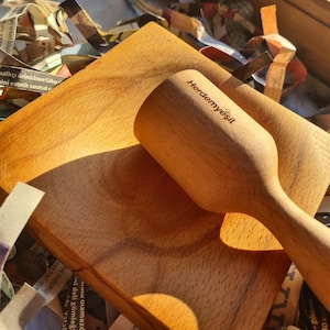 Op de afbeelding: Een houten vijzel en stamper set met de tekst "Herdemyeşil" gegraveerd op de zijkant van de stamper. De set is gemaakt van lichtbruin hout en staat op een houten oppervlak.