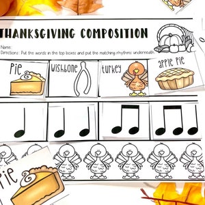 May include: A Thanksgiving-themed educational worksheet featuring illustrations of pie, wishbone, turkey, and apple pie. The worksheet includes musical notes and the words "Thanksgiving Composition". Additional cards with illustrations and words are scattered around.